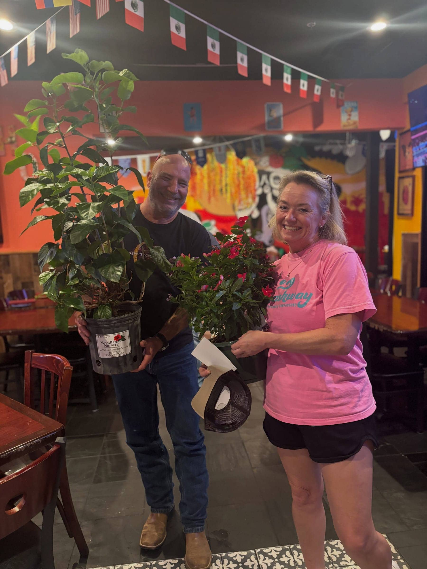 Two customers holding flowering plants from Woodlands Nursery