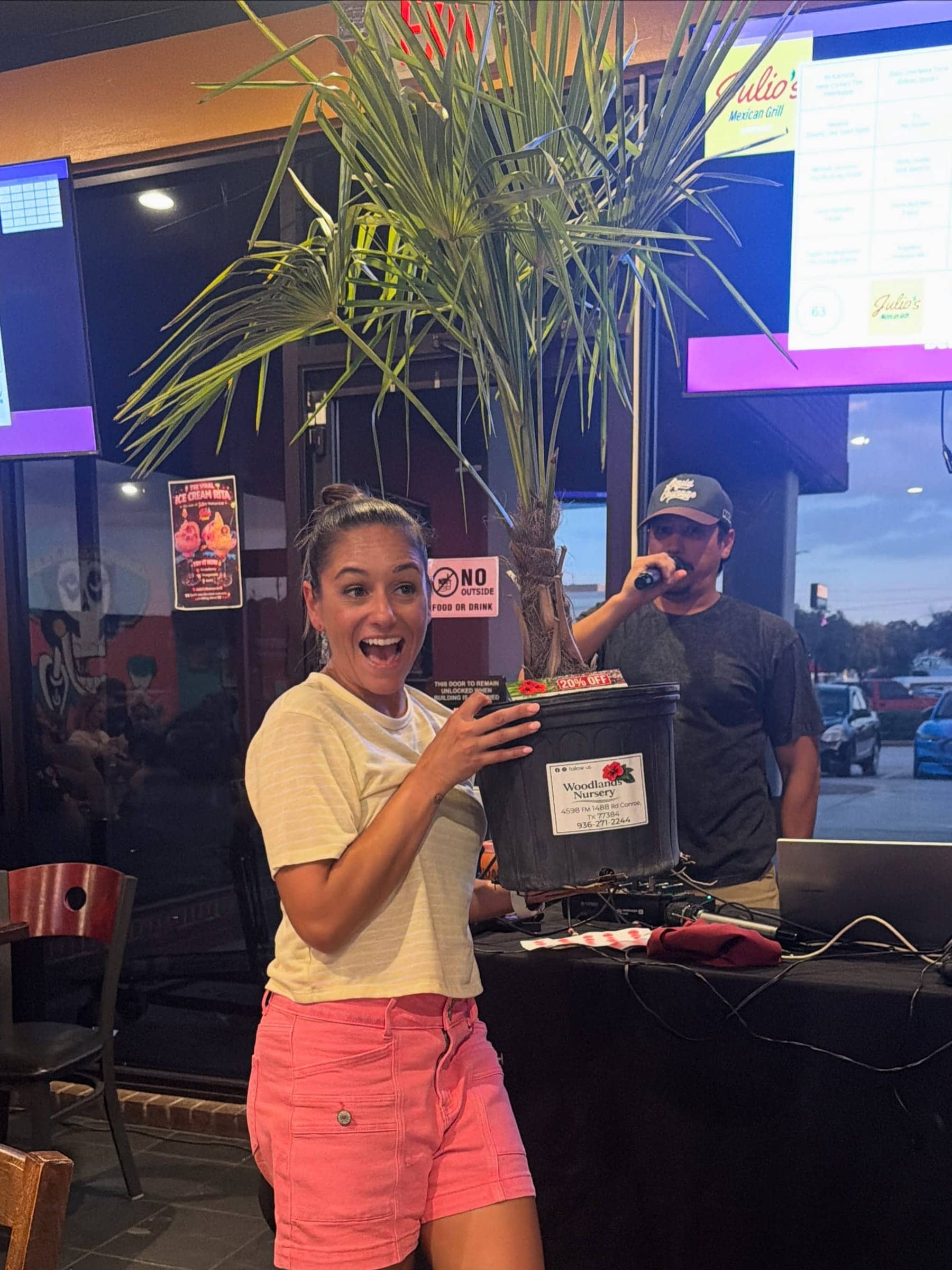 A customer holding a potted palm